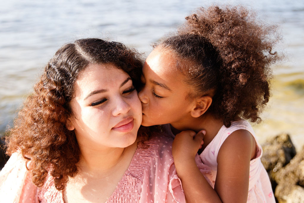 Mother in a wheelchair holding young daughter in her lap