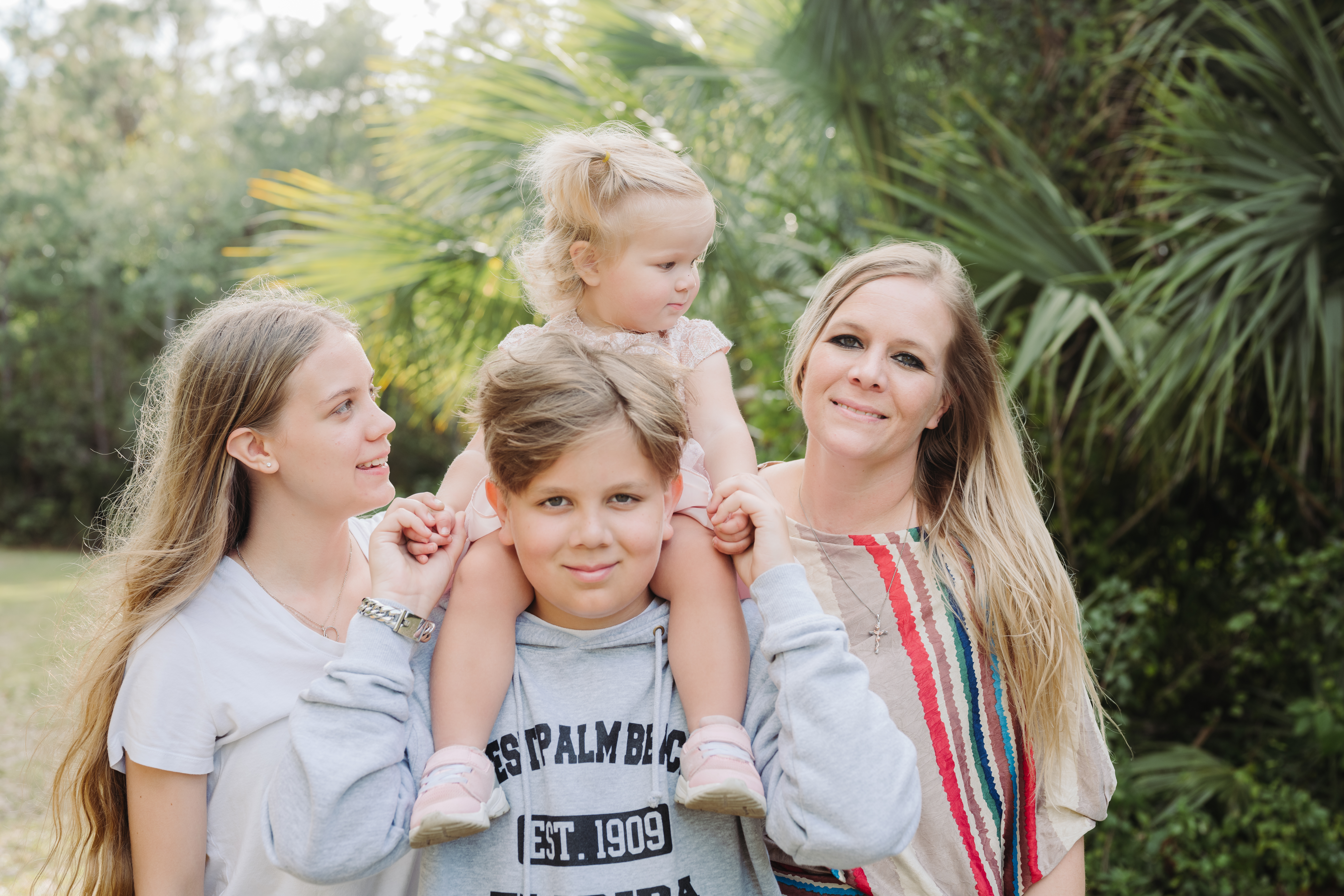 Mother with son and two daughters standing together in garden