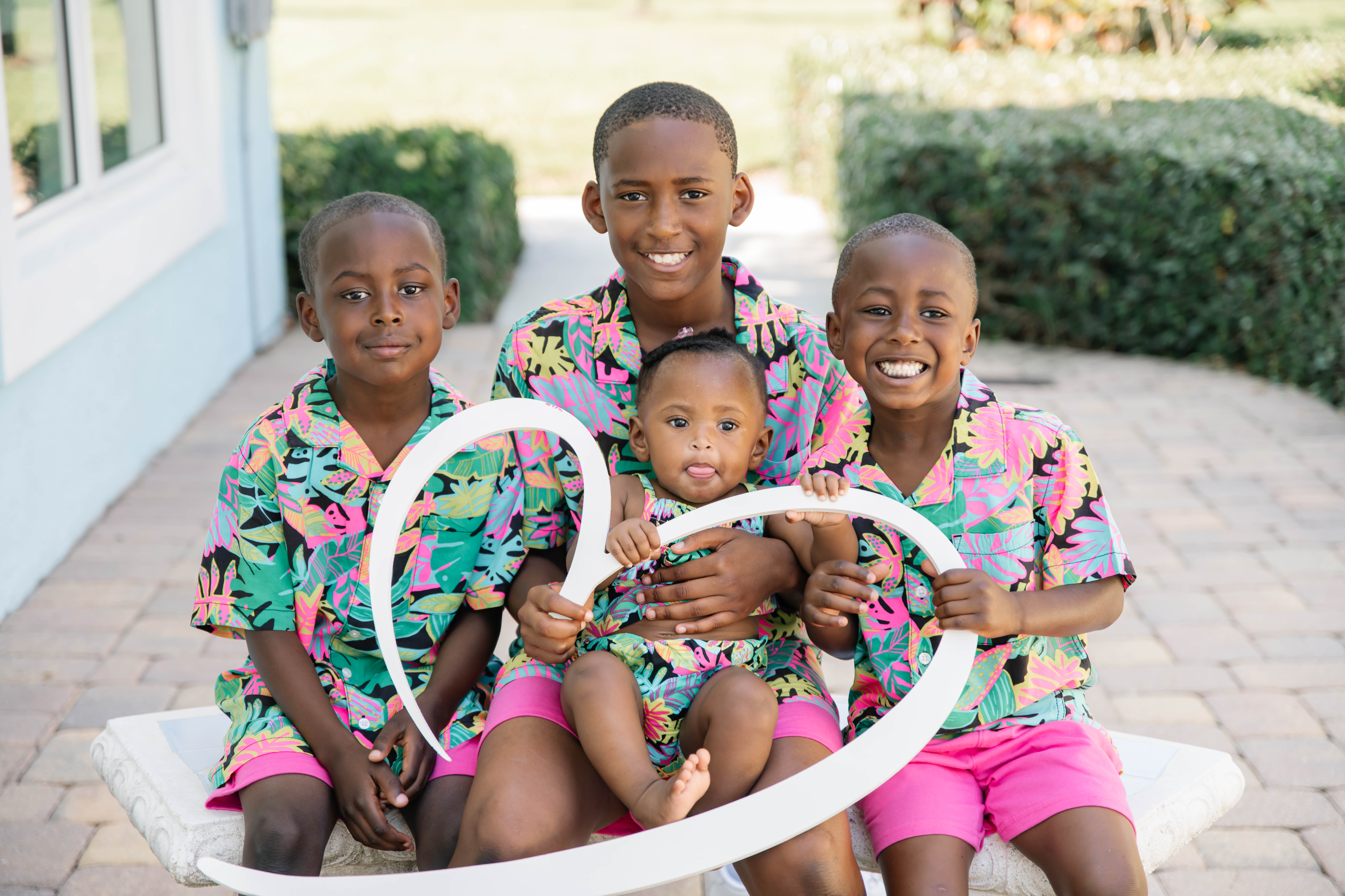 Four small siblings, holding a white heart cutout. 