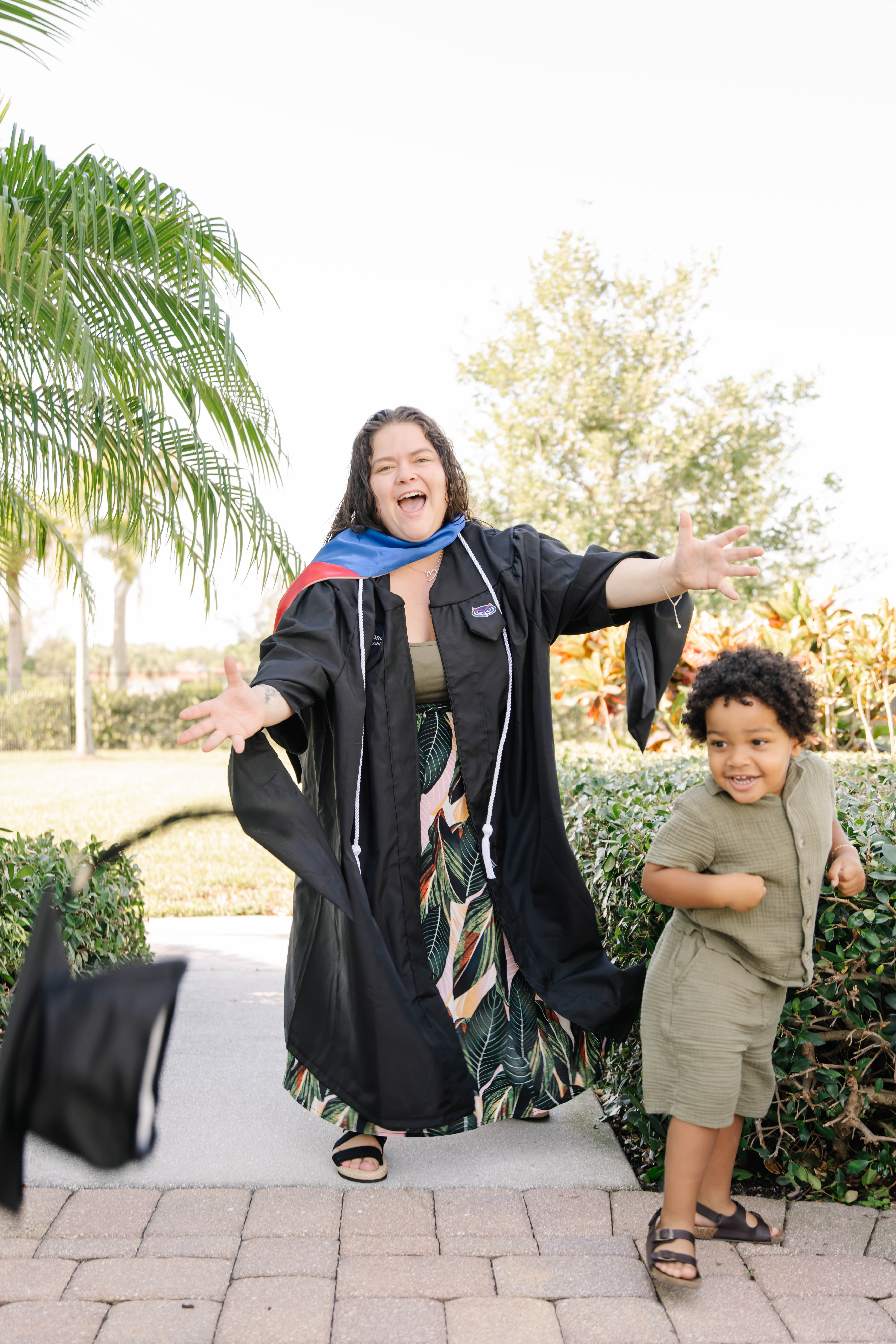 Mom in graduating gown with small son
