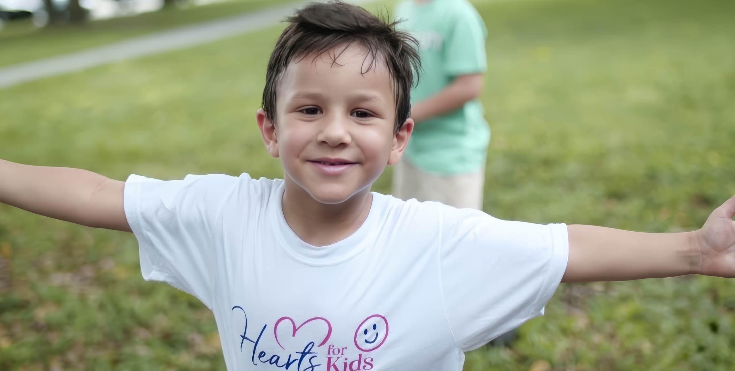 Young boy outside, arms out wide
