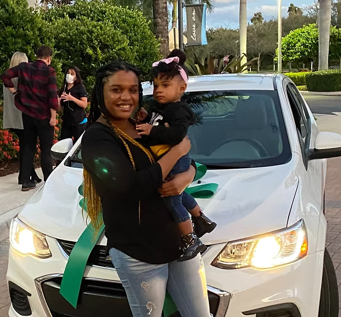 Leah, a resilient young mother, pictured with her daughter after moving to West Palm Beach and receiving support and a car from Hearts For Moms to pursue educational and personal goals.